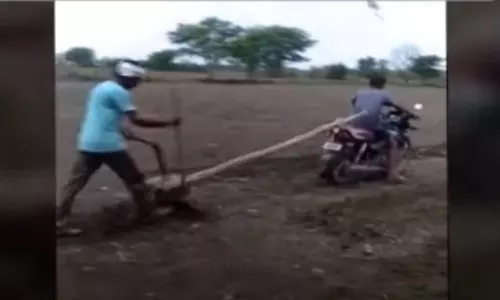 Farmer Plowing a Field with Bike