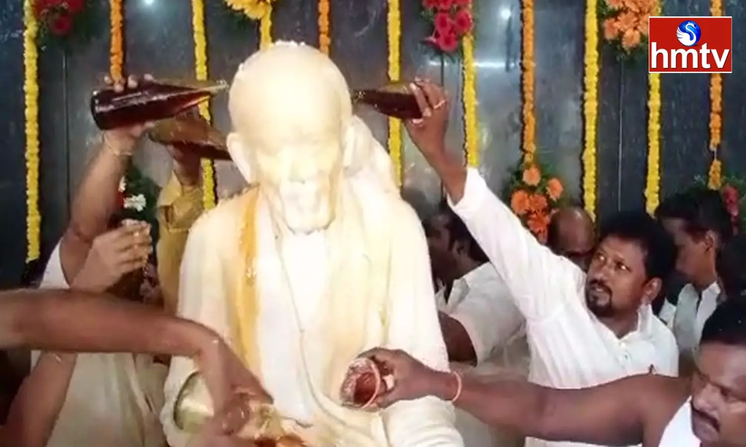 Abhishekam to Baba idol with honey brought in liquor bottles in West Godavari District