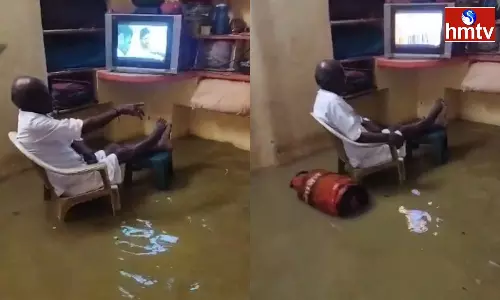 A Person Watching TV Despite The Heavy Rain Coming Into The House