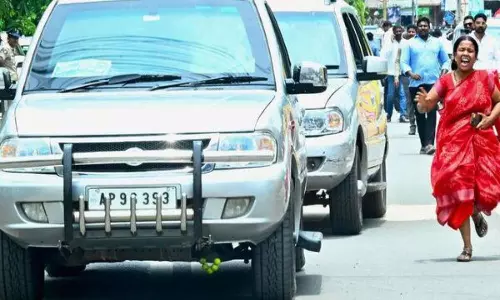 A woman runs along the convoy for Chandrababu