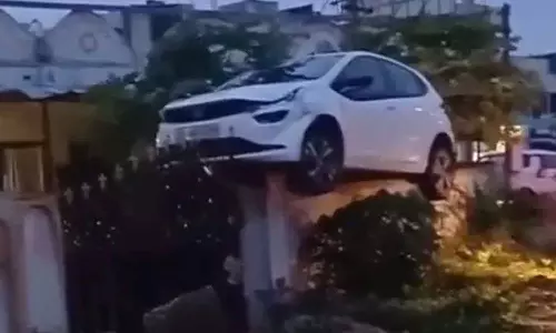 ఇదెలా సాధ్యం అయిందిరా బాబూ.. కారును కాంపౌండ్ వాల్ ఎక్కించిన డ్రైవర్..